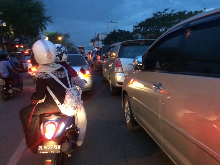 keadaan Jalan di samping masjid raya ketika jam sholat , jalan muhammad jam. mobil parkir dua baris kiri -kanan jalan.