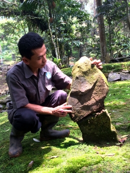 Kang Deni menunjukkan dua batu yang disatukan dan membentuk wajah. Foto: Diella Dachlan