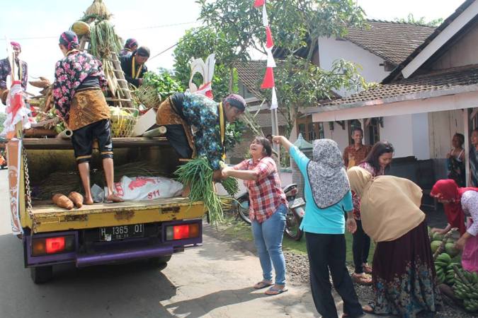 Warga menyerahkan hasil bumi pada rombongan (foto; dok pri)