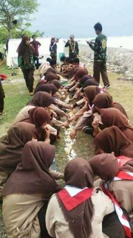 Para Pramuka puteri yang terpaksa makan nasii di atas tanah itu. (Foto: Asep Saepul)