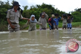 Sejumlah guru sedang melewati sungai untuk pergi ke sekolah. (Foto : Republika)