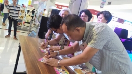 Pepih Nugraha dan Nurulloh menandatangani buku yang baru diluncurkan/foto dari facebook Christie Damayanti