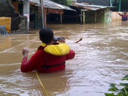 Eko sedang mengevakuasi seorang anak yang terjebak banjir, Jakarta (2014)