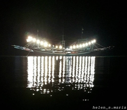 Kapal nelayan di waktu malam.