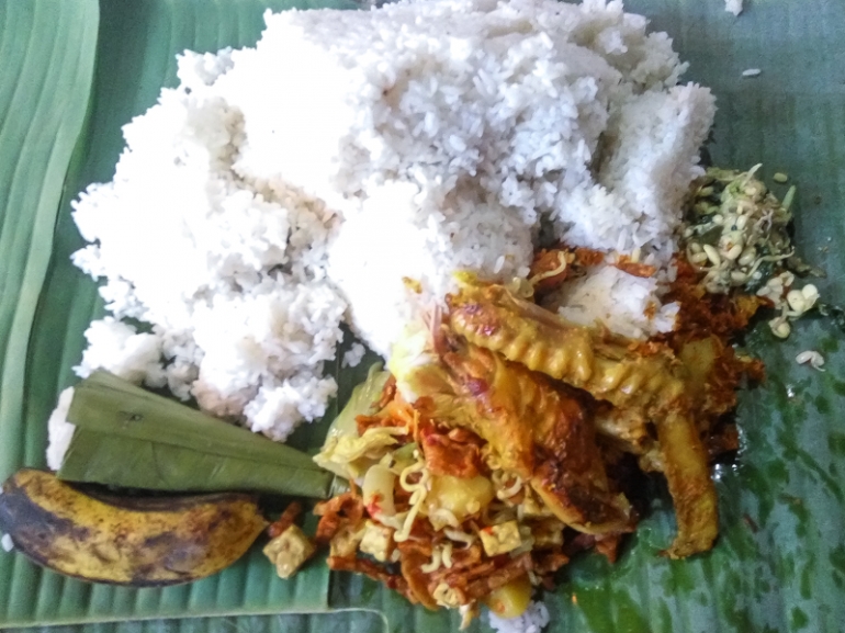 nasi yang sudah dibagi beralasa daun pisang. Ada apem, pisang, pangang, serudeng dan nasi gurih perlambang adi doa dan harapan