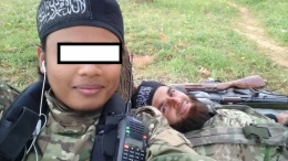 salah satu anggota ISIS asal Indonesia mengunggah foto dirinya (selfie) di akun facebook mengenakan atribut a la jihadis: senapan laras panjang dan ikat kepala berlafazkan kalimat tauhid. (foto sumber: website Jihad Selfie)