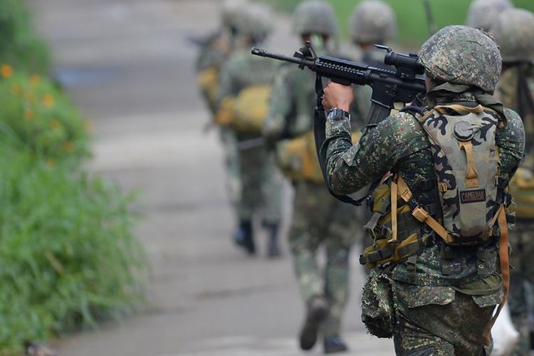 Seorang personel marinir Filipina membidik senapan serbunya saat berpatroli di kota Marawi, Mindanao.(TED ALJIBE / AFP )