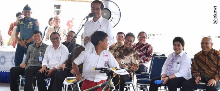 Presiden Jokowi saat memberikan hadiah sepeda kepada salah satu peserta kuis. Sumber : berita186.com