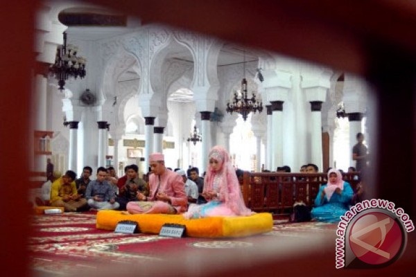 Sepasang penganten duduk memanjatkan doa ketika mengikuti prosesi adat pernikahan di Mesjid Raya Baiturrahman, Banda Aceh, Sabtu (2/11/2013). Sepekan terakhir, Aceh pernah mengalami krisis buku nikah bahkan stok buku nikah di kantor Kementerian Agama Aceh kosong. (ANTARA FOTO/Ampelsa)