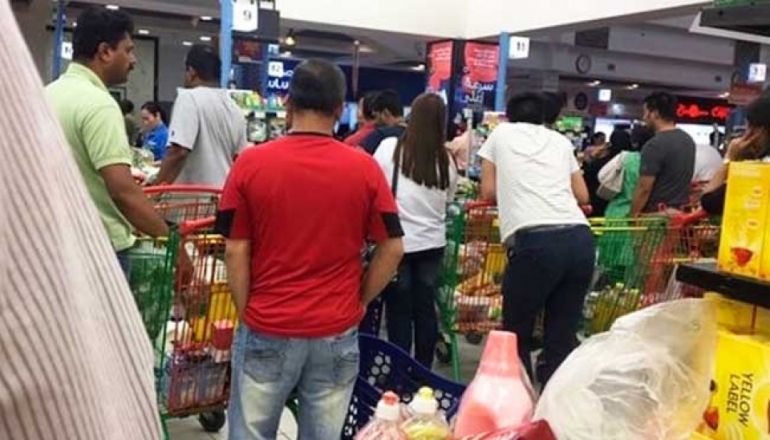 Bloomberg.com | People stand in a line to buy food at a supermarket in Doha.Photographer: @shalome05 via AP
