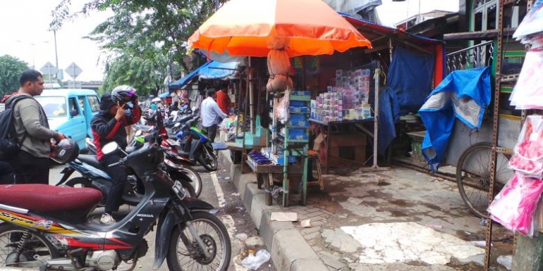 Para pedagang kaki lima yang sempat berjualan di tempat relokasi Pasar Cipinang Besar Selatan kembali berjualan di trotoar Jalan Basuki Rahmat, Jakarta Timur, Senin (24/2/2014). Pedagang mengaku merugi karena lapak mereka di pasar itu sepi pembeli.(KOMPAS.com/ROBERTUS BELARMINUS)