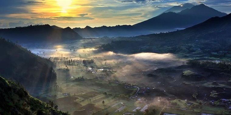 Pemandangan indah matahari terbit di Bukit Pinggan Kintamani, Bali ketika ada sedikit kabut. Foto courtesy : Balidirection.com 