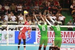 Pemain Indonesia, Rivan Nurmulki melancarkan spike ke arah dua blocker Arab Saudi| Foto: PBVSI
