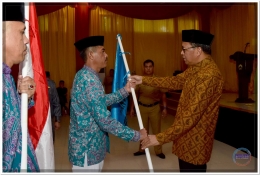 Penyerahan Bendera dari Bupati Bantaeng (kanan) kepada perwakilan Kloter 02 JCH Kabupaten Bantaeng pada Pelepasan di Balai Kartini Bantaeng (25/07).