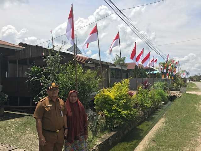 Masriati (54) usai memasang bendera di depan rumahnya