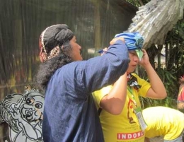 Panitia membantu pasang ikat kepala (Foto : Ko In)