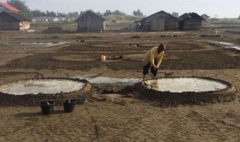 Seorang petani garam sedang membuat tabung penampung air garam di Desa Lancok, Kecamatan Syamtalira Bayu, Aceh Utara, pada Selasa (02/08/2017). Di sana, harga bibit untuk diekstrak menjadi garam, terlalu mahal yaitu Rp 300.000 per 50 kilogram. Dulu, hanya Rp 100.000. Selisih biaya produksi garam dan hasil penjualan garam, tidak cukup untuk mendongkrak daya beli mereka. Foto: masriadi-Kompas.com