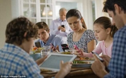 Ilustrasi keluarga yang sibuk dengan ponsel masing-masing saat makan bersama (sumber: dailymail.co.uk)