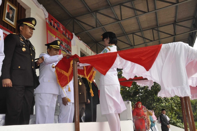 Bupati Bangka menyerahkan bendera Merah Putih untuk dikibarkan. (Dok. Humas Pemkab Bangka)