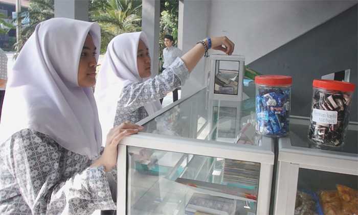 Memasukkan sendiri uang pembayaran di kotak tersedia. Tanpa ada petugas jaga di Kantin Kejujuran, uang kembalian juga bisa diambil sendiri. (Foto: Gapey Sandy)