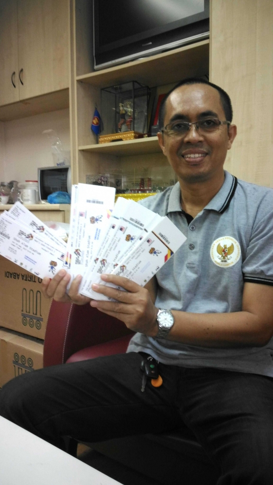 Salah seorang guru Sekolah Indonesia Kuala Lumpur memegang tiket untuk dibagikan kepada siswa SMA-SIKL.