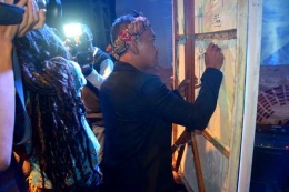 Ketua Komunitas BIOTIC SADULUR, Ahep, sedang menandatangani Lukisan karya Bahar Malaka yang akan diserahkan kepada Pemerintah Kabupaten Sumedang. (Sumber foto: Biotic Sadulur)