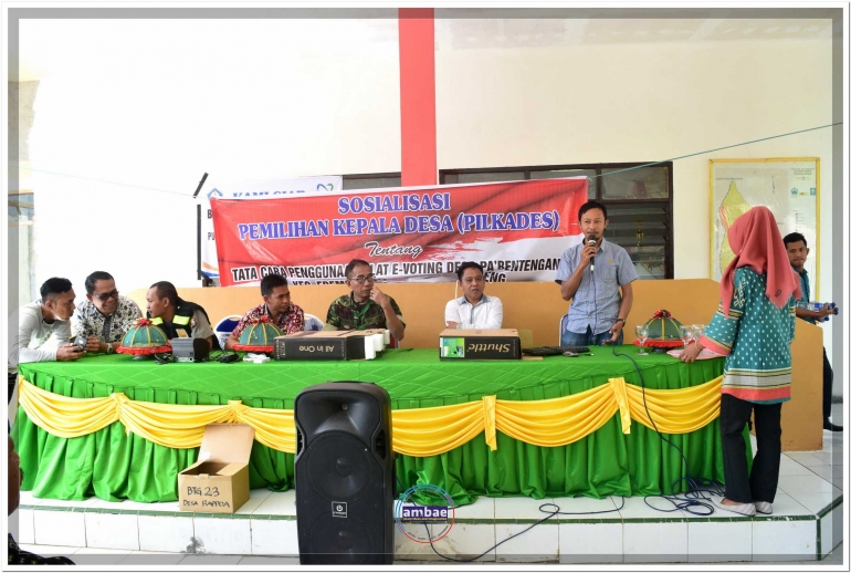 Tim Teknis (kanan) jelaskan tata cara Pemungutan Suara dengan E-Voting sebelum lakukan praktek menggunakan peralatan bersama warga Desa Pa'bentengang, Bantaeng (27/08).