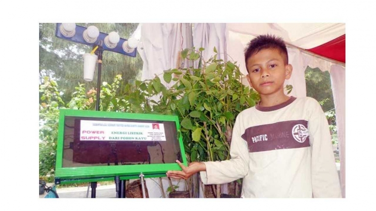 Naufal, pelajar kelas 2 MTsN Kota Langsa memperlihatkan temuannya berupa sumber energi listrik dari pohon kedondong di stan Teknologi Tepat Guna (TTG) Aceh bertempat di Stadion Harapan Bangsa, Lhong Raya, Banda Aceh, Jumat (9/10). (SERAMBI/ NURUL HAYATI)