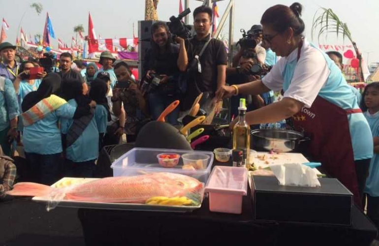 Menteri Kelautan dan Perikanan, Susi Pudjiastuti, unjuk kebolehan memasak ikan di hadapan nelayan Muara Angke, Jakarta Utara. Ini bagian dari upaya untuk meningkatkan konsumsi ikan, yang tentu saja juga akan memberi dampak positif bagi kesejahteraan nelayan. Foto: dokumentasi KKP