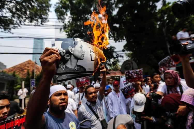 Pengunjuk rasa membakar poster bergambar tokoh Myanmar Aung San Suu Kyi di depan Kedutaan Besar (Kedubes) Myanmar di Jalan Agus Salim, Menteng, Jakarta Pusat, Sabtu (2/9/2017). Massa mengecam tindakan kekerasan terhadap umat Islam Rohingya dan menyerukan agar duta besar Myanmar diusir dari Indonesia.(KOMPAS.com/GARRY ANDREW LOTULUNG)