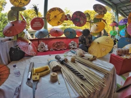 Seorang perajin payung sedang melukis payung untuk memperindah payung yang dibuatnya. (Foto: dok.pri.)