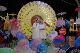 Para pengunjung mengabadikan momen dengan berpose di stand foto yang telah disediakan dengan latar sebuah payung besar dan payung-payung berukuran lebih kecil sebagai ornamen penghias. (Foto: dok.pri.)