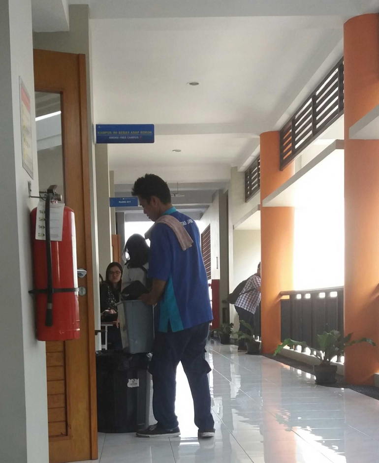 Petugas CS membersihkan kelas setelah selesai digunakan.