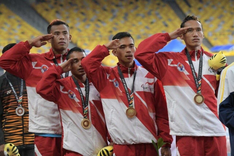 Atlet-atlet Indonesia memberikan hormat saat Bendera Merah Putih dikibarkan dalam Upacara Pengalungan Medali ASEAN Para Games 2017. Sumber foto: sportourism.id