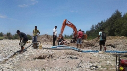 Operator alat berat sedang menggeruk lubang bagi penampungan air dari Sungai Talau (Foto:PDAM Belu)