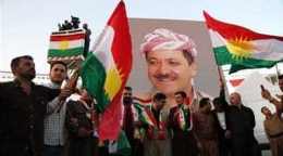 Kaum Kurdi mengusung poster besar Masoud Barzani dan mengibarkan bendera Kurdi (Aljazeera.com)