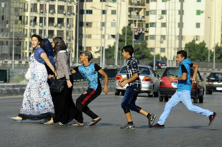 Ilustrasi: Seorang pemuda Mesir, yang diikuti oleh teman-temannya, meraba-raba seorang wanita saat dia melintasi sebuah jalan di Kairo. (Sumber: Ahmed Abd El Latif/AFP-www.npr.org)