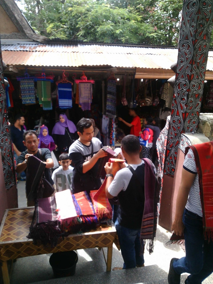 Pengujung yang akan memasuki Pemakaman Raja Sidabutar sedang mengenakan ulos batak. Foto diambil dari dalam lokasi kuburan-Dokumentasi Pribadi