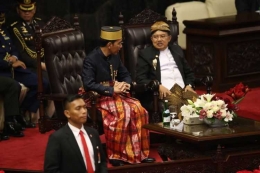 Jusuf Kalla dalam balutan busana Jawa tengah berbincang dengan Presiden Joko Widodo saat hadir dalam sidang tahunan MPR 2017. Foto: KOMPAS.com / GARRY ANDREW LOTULUNG