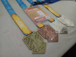 Deskripsi : medali yang diterima kepada peserta ajang lari Mandiri Jakarta Marathon 2017 I Sumber Foto : Andri M
