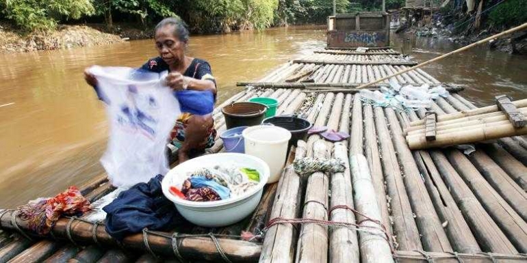 Seorang warga Kebon Pala, Kampung Melayu, Jakarta, mencuci pakaian di aliran Sungai Ciliwung yang keruh dan penuh sampah. Indonesia masih buruk dalam masalah sanitasi dan akses terhadap air bersih. Warga miskin akhirnya mengesampingkan persoalan kebersihan dan kesehatan hidupnya.(KOMPAS/LUCKY PRANSISKA)