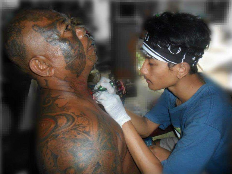 Proses tatto kupu-kupu pada leher Sujati (facebook.com/sujati.bali.3)