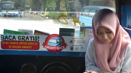 penumpang asyik membaca buku di angkot baca (Zainul Arifin/liputan6.com)