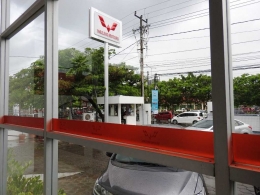 Papan nama Wuling Motors di Jalan AP. Pettarani, Makassar (pemandangan dari dalam showroom)