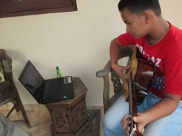 Defri belajar dari Youtube untuk mengasah kemampuannya bermain gitar (dok pri).