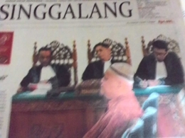 Yusafni berpeci haji kelihatan tenang saat mendengarkan dakwaan jaksa dalam sidang di Pengadilan Tipikor Padang. (DOK REPRO. HARIAN SINGGALANG)