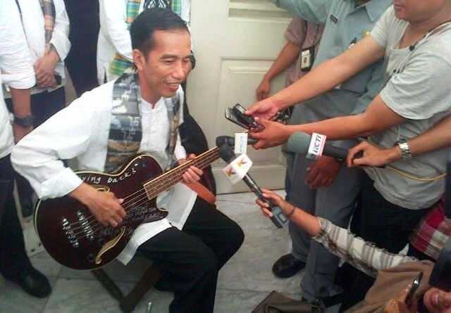 Jokowi memainkan Gitar bass hadiah dari grup band Metallica (Tribunnews.com)