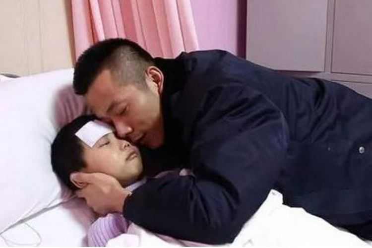 Zhang Jiaye (7), terbaring di ranjang rumah sakit dan dipeluk ayahnya.