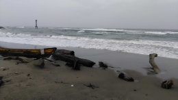 Bebearapa potongan kayu tergeletak begitu saja di tepi pantai