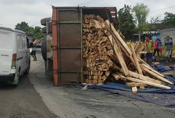 Truk terbalik sedang ditangani petugas dan masyarakat setempat. (@iskandarjet)